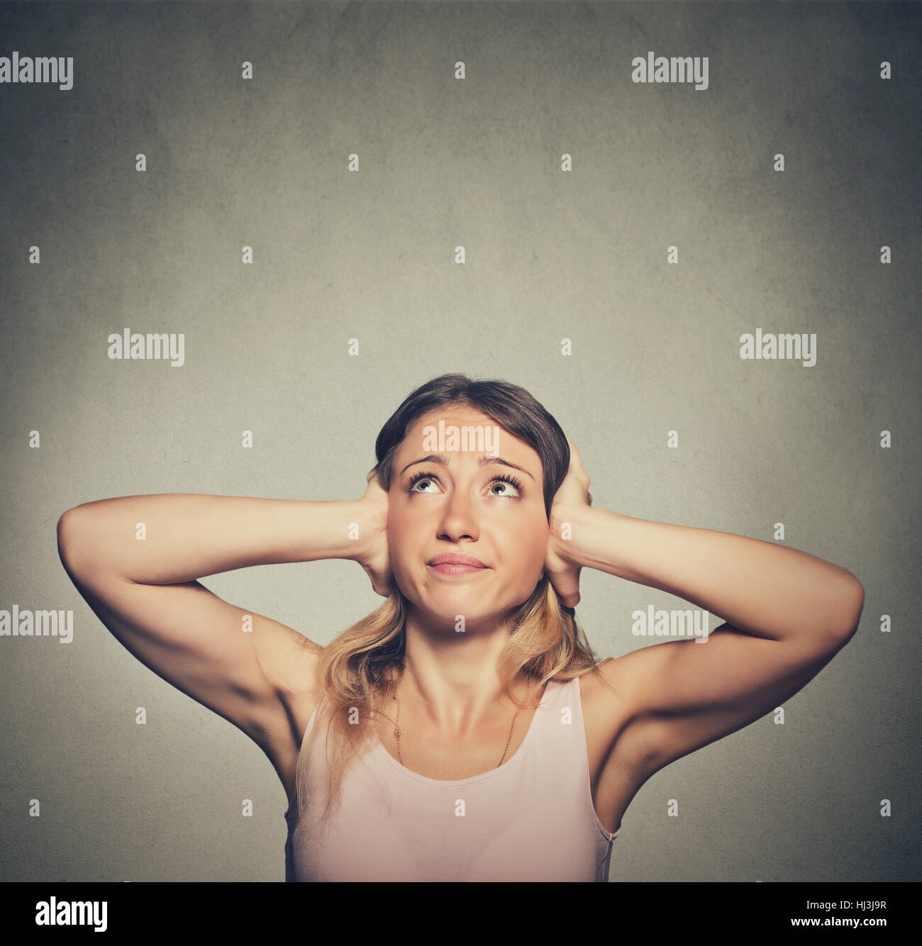 angry unhappy stressed woman covering her ears looking up stop making