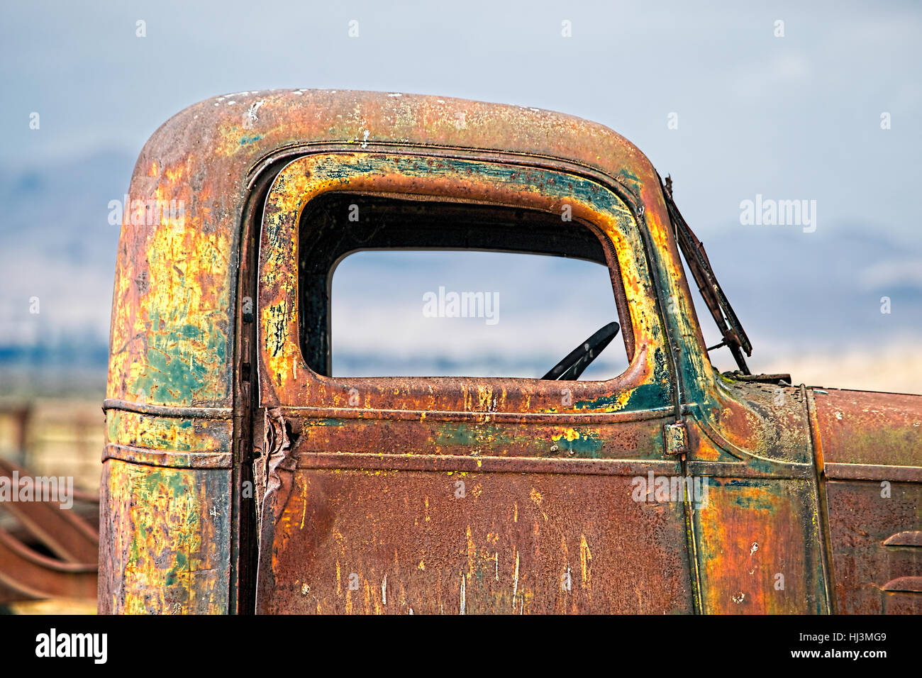 Lateral detail of the window of an old Chevrolet Truck abandoned in a pasture field in California.  This old 1940s era Chevrolet truck has been rustin Stock Photo