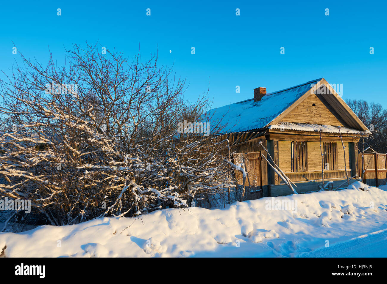 Abandoned house in Nekhina Gora village, Ostashkovskiy district, Tver oblast, Russia, January 2017 at sunset time. Stock Photo