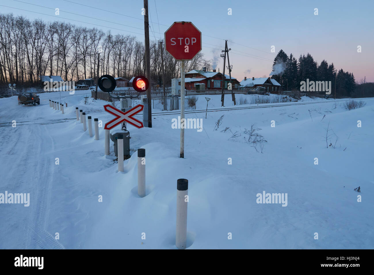 Railroad crossing in winter at sunset. Ostashkovskiy district, Tver oblast, Russia. Stock Photo
