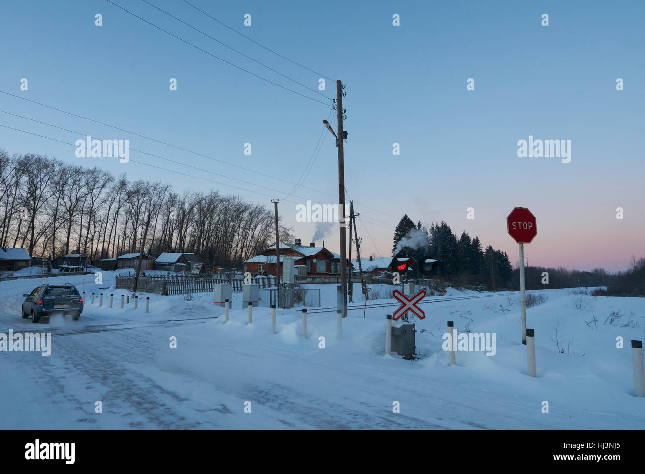 Car crosses railroad at red stop signal. Ostashkovskiy district, Tver oblast, Russia, January 2017. Stock Photo