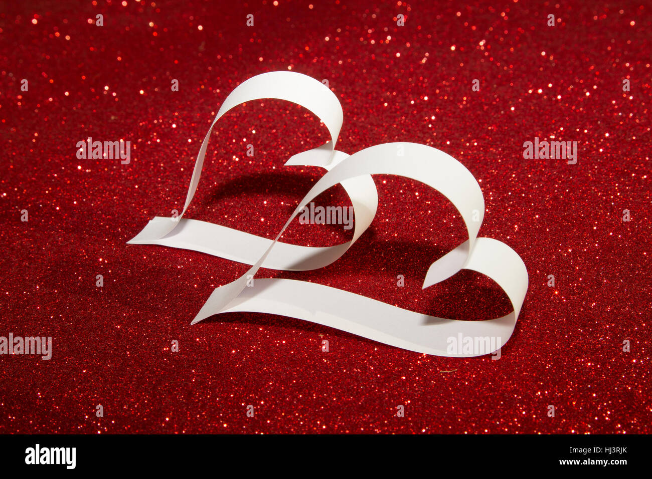 Two white hearts from paper on red shining background Stock Photo - Alamy
