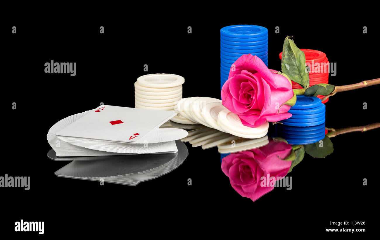 Deck of cards made into a gamblers rose with a flower and poker chips Stock Photo