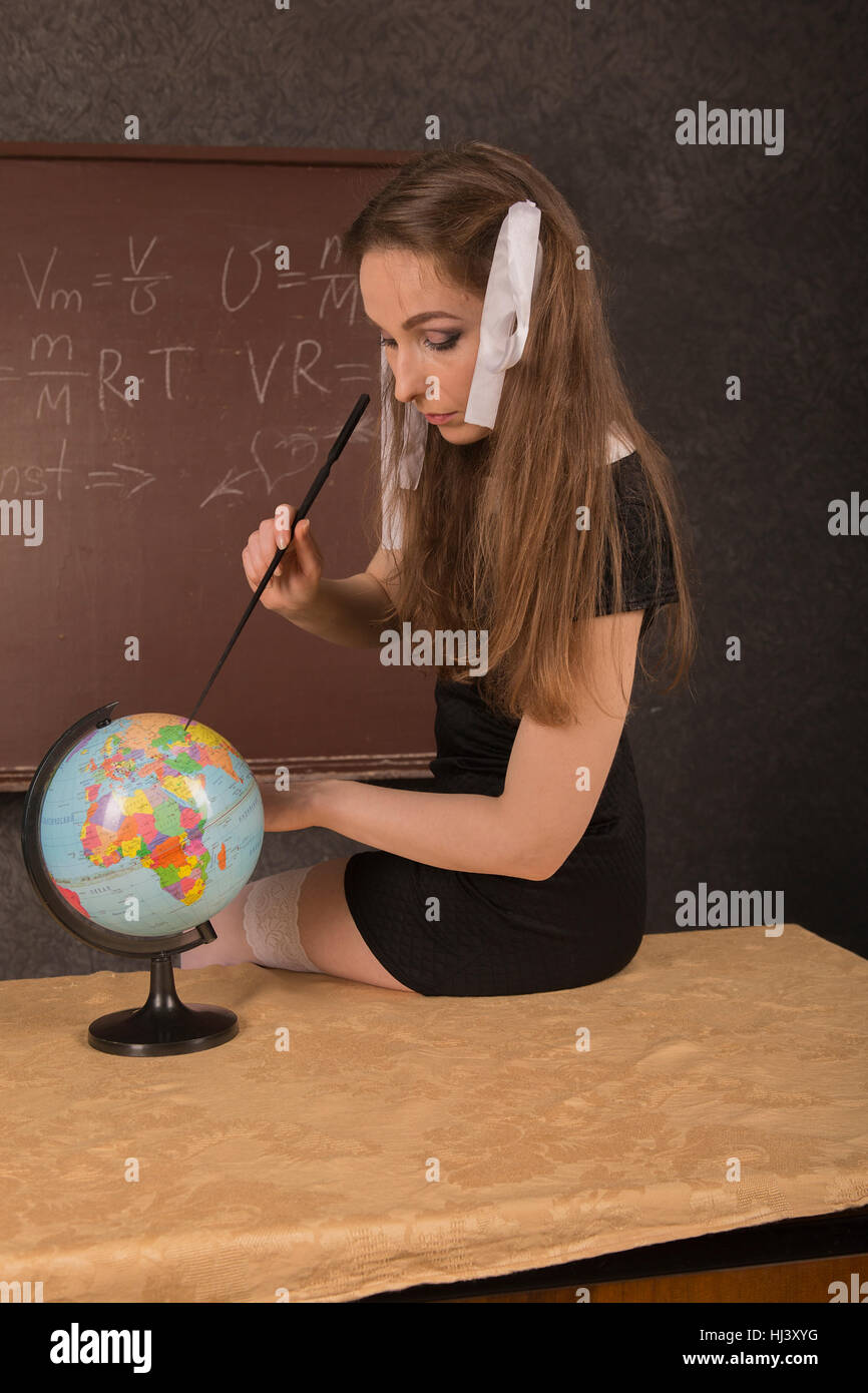 Charming girl shows the country on the globe. Stock Photo