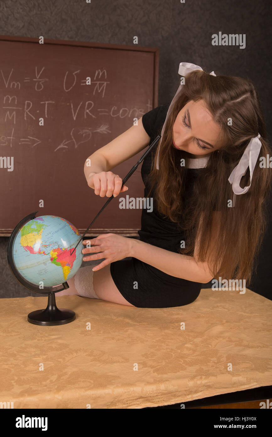 Charming girl shows the country on the globe. Stock Photo