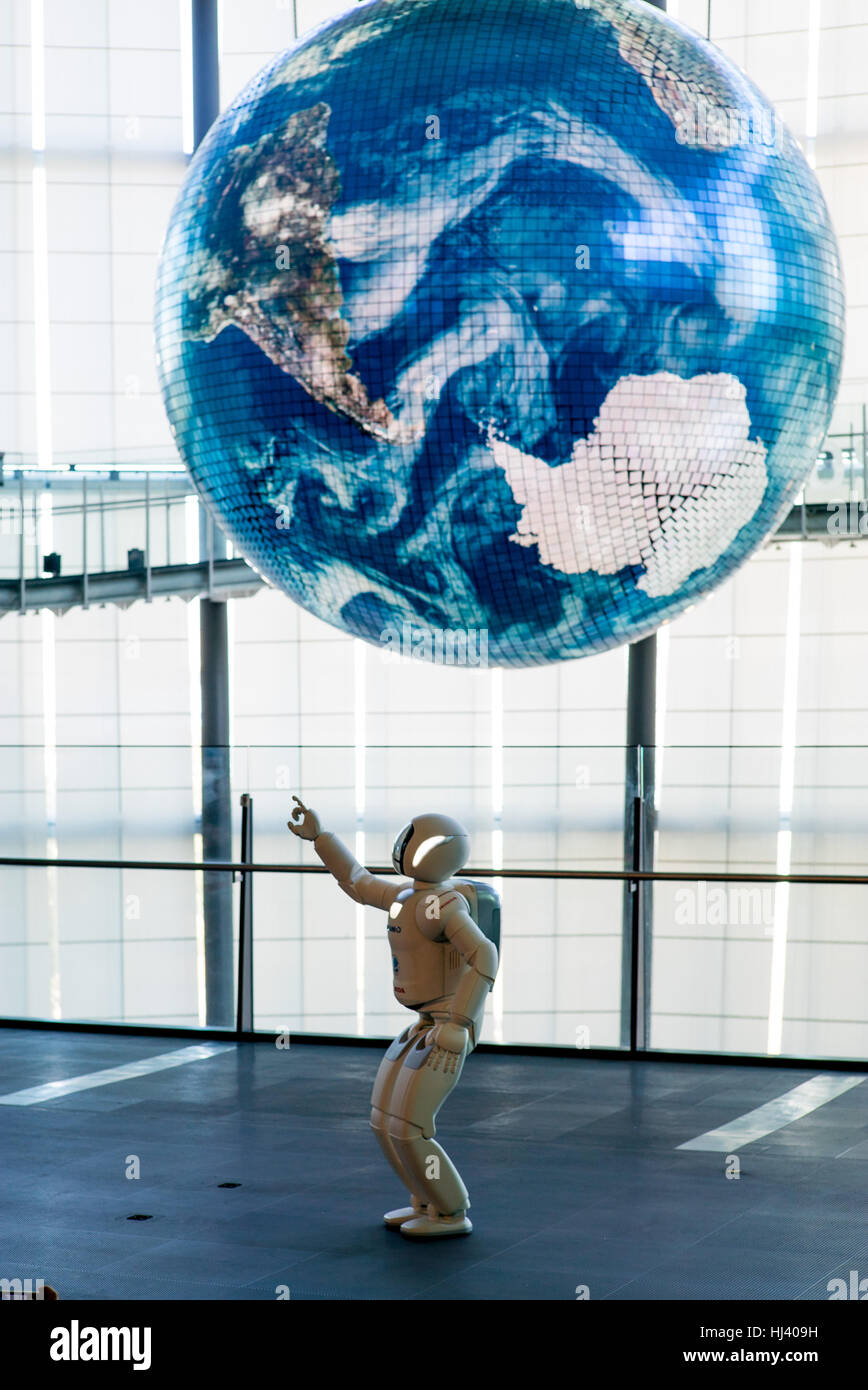 Honda's ASIMO robot points towards a giant earth at The National Museum of Emerging Science and Innovation (Miraikan) Stock Photo