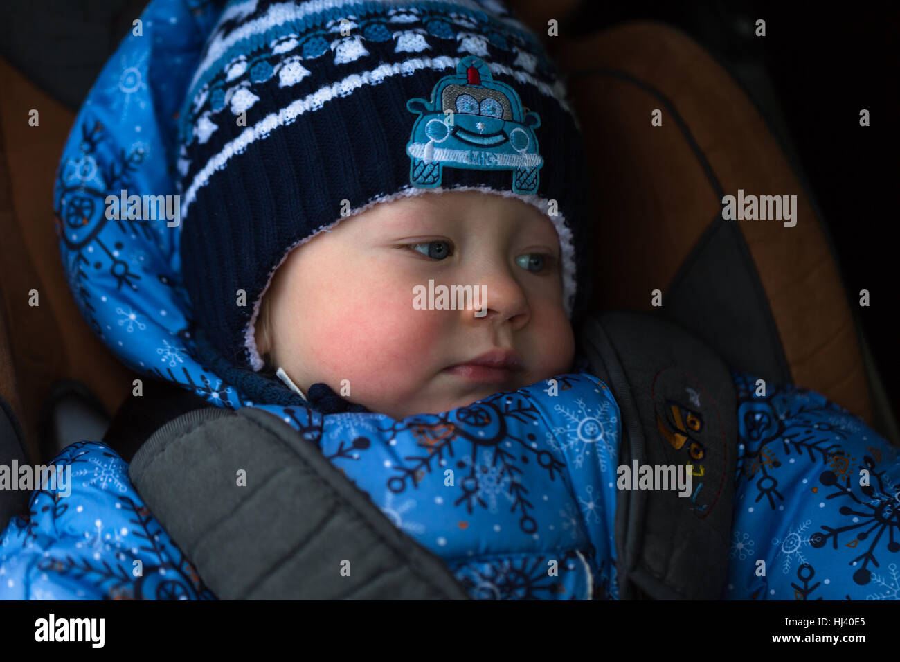 little boy in winter clothes in a child car seat Stock Photo