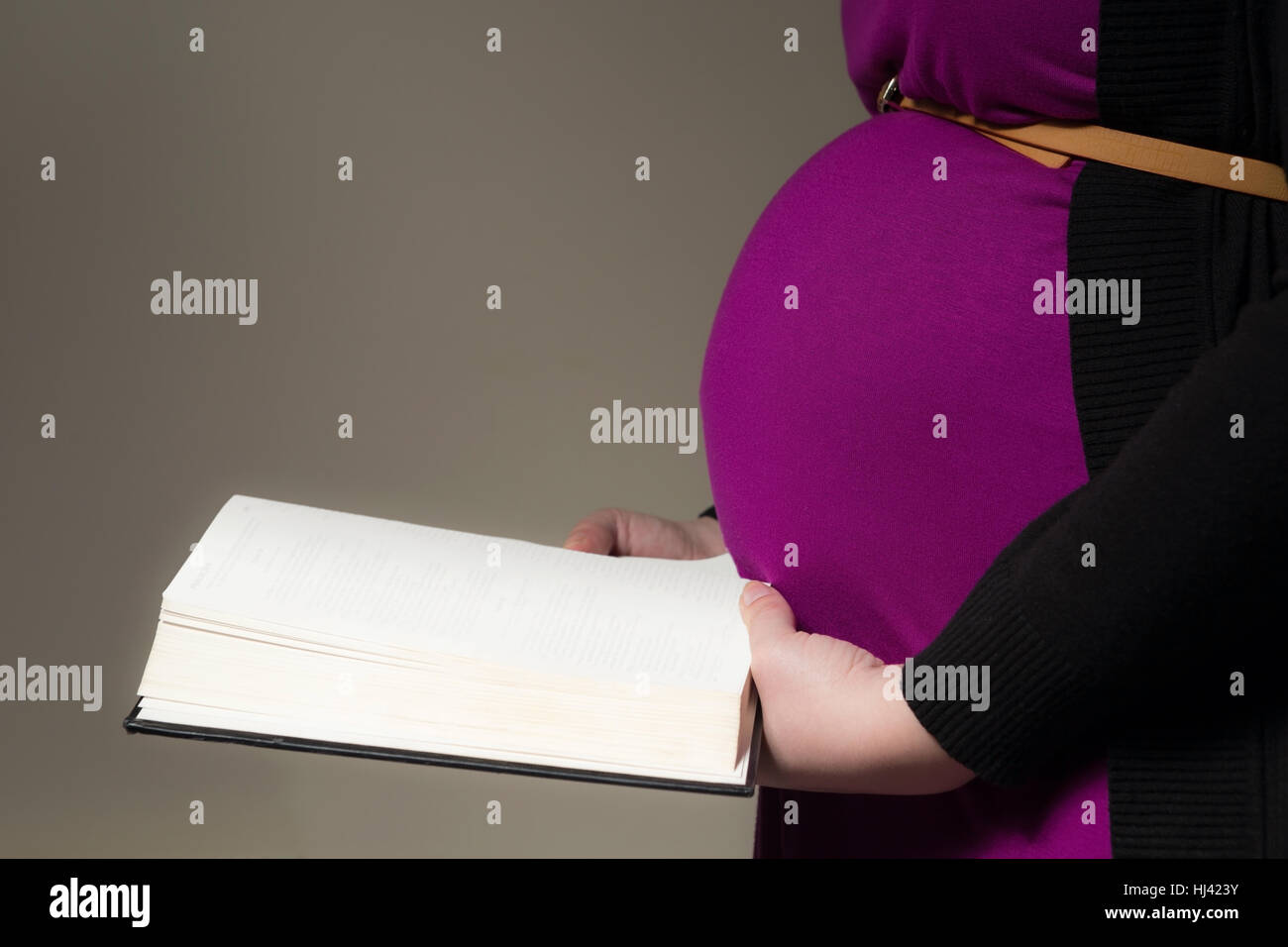 Pregnant mother reading the KJV Bible to her unborn child Stock Photo