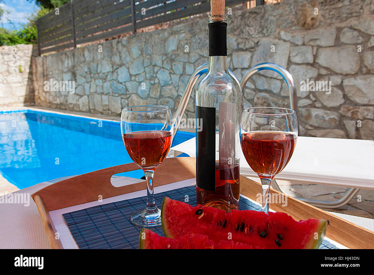 2 glasses and bottle of wine at poolside, romance Stock Photo