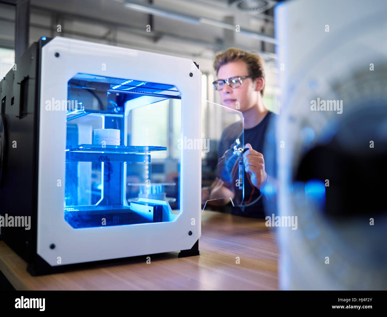 Employee, 25-30 years, opening 3D printer in production laboratory, FabLab, Wattens, Tyrol, Austria Stock Photo