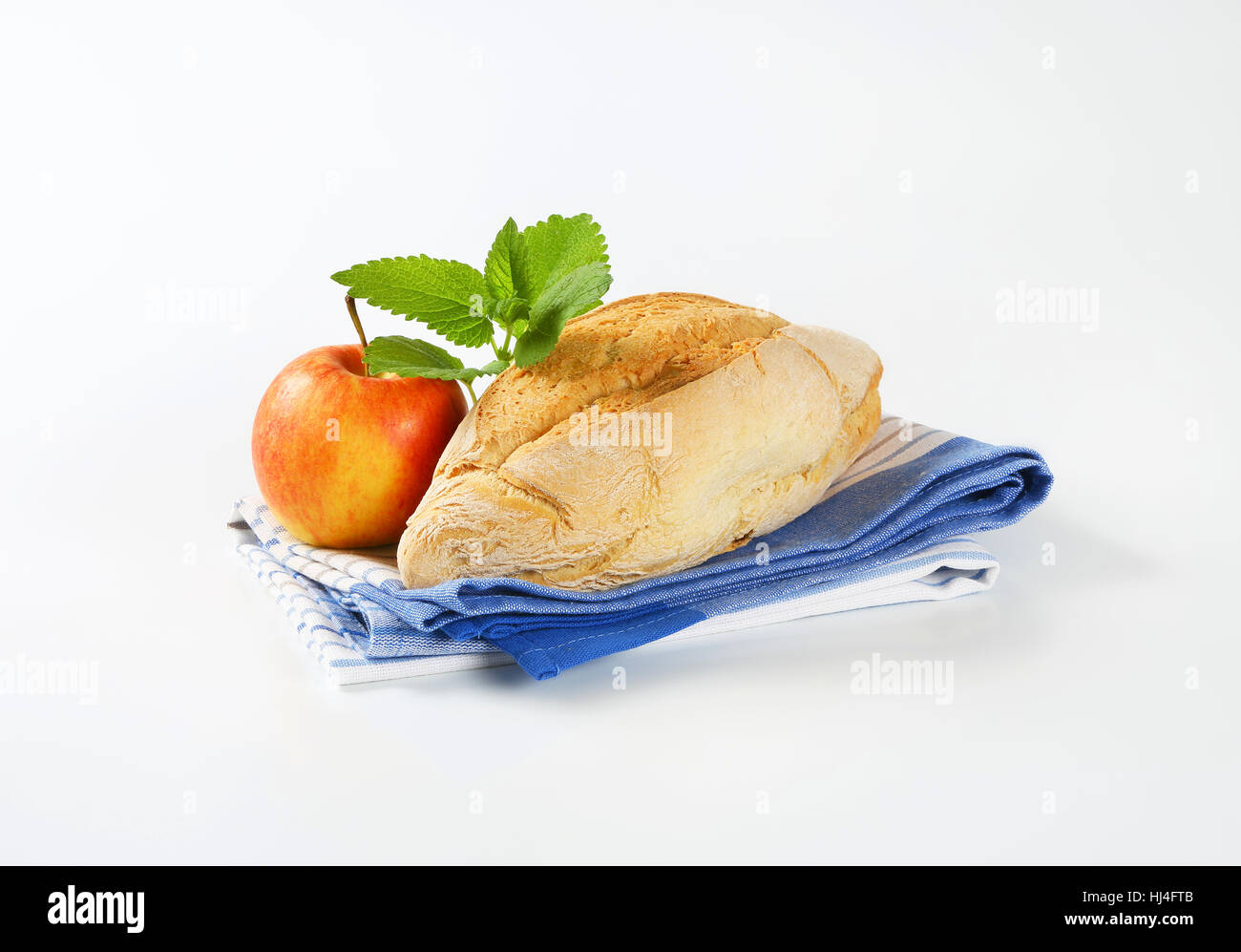 diamond shaped ciabatta bread and fresh apple on striped dishtowel Stock Photo