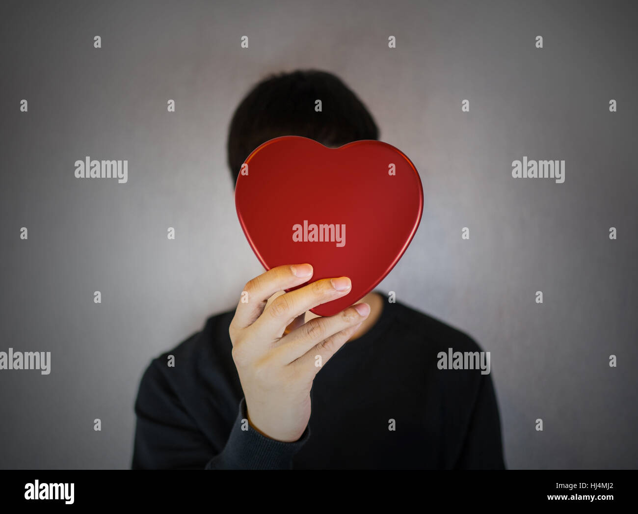 Man holding red heart shape covering face Stock Photo Alamy
