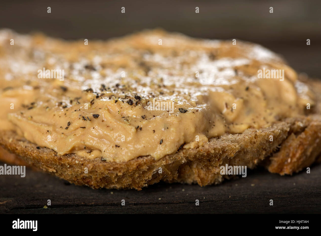 Close up of bread slice with homemade pork liver pate on wooden background Stock Photo