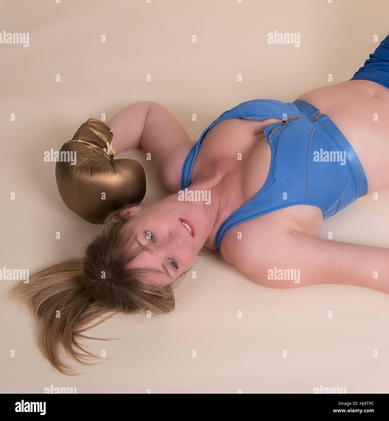 Woman boxer laying on the floor. Out for the count Stock Photo
