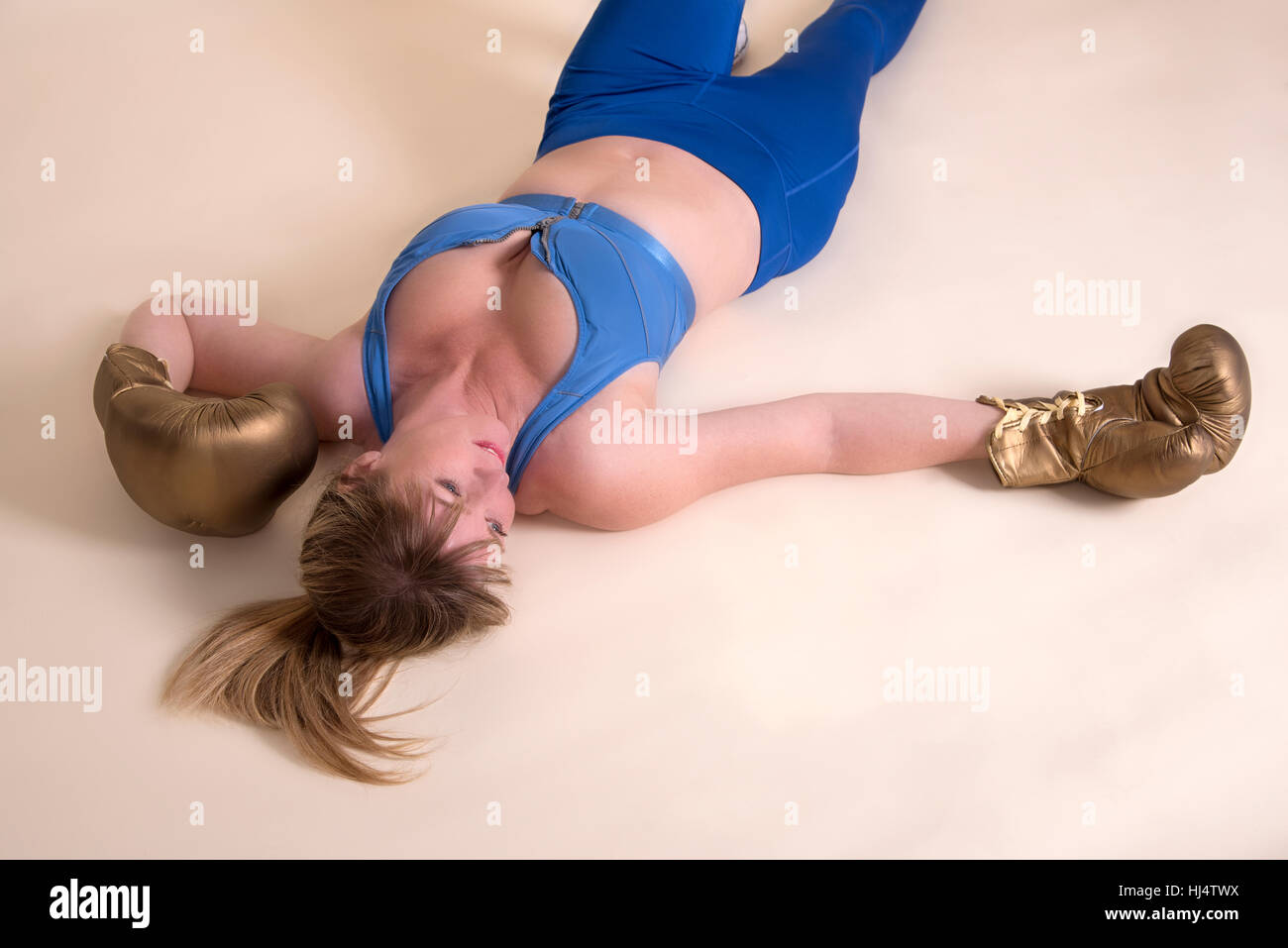 Woman boxer laying on the floor. Out for the count Stock Photo
