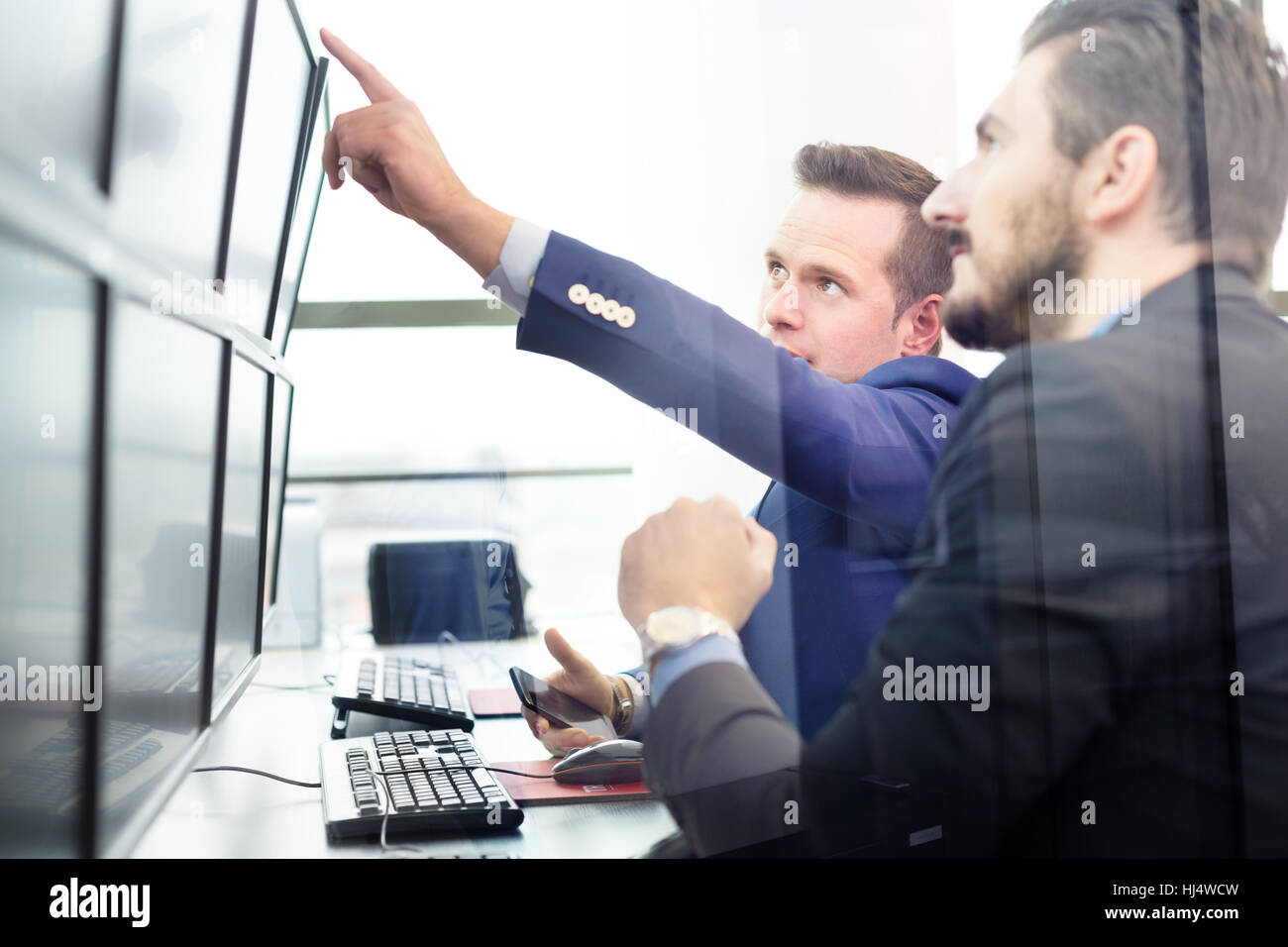 Stock traders looking at computer screens. Stock Photo