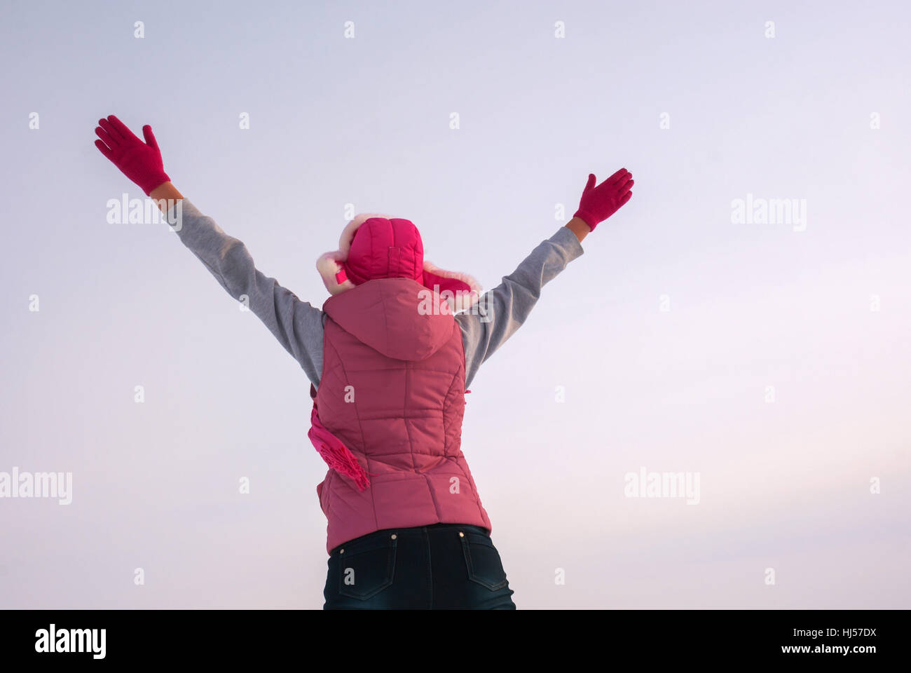 Teen girl staying with raised hands against blue sky Stock Photo - Alamy