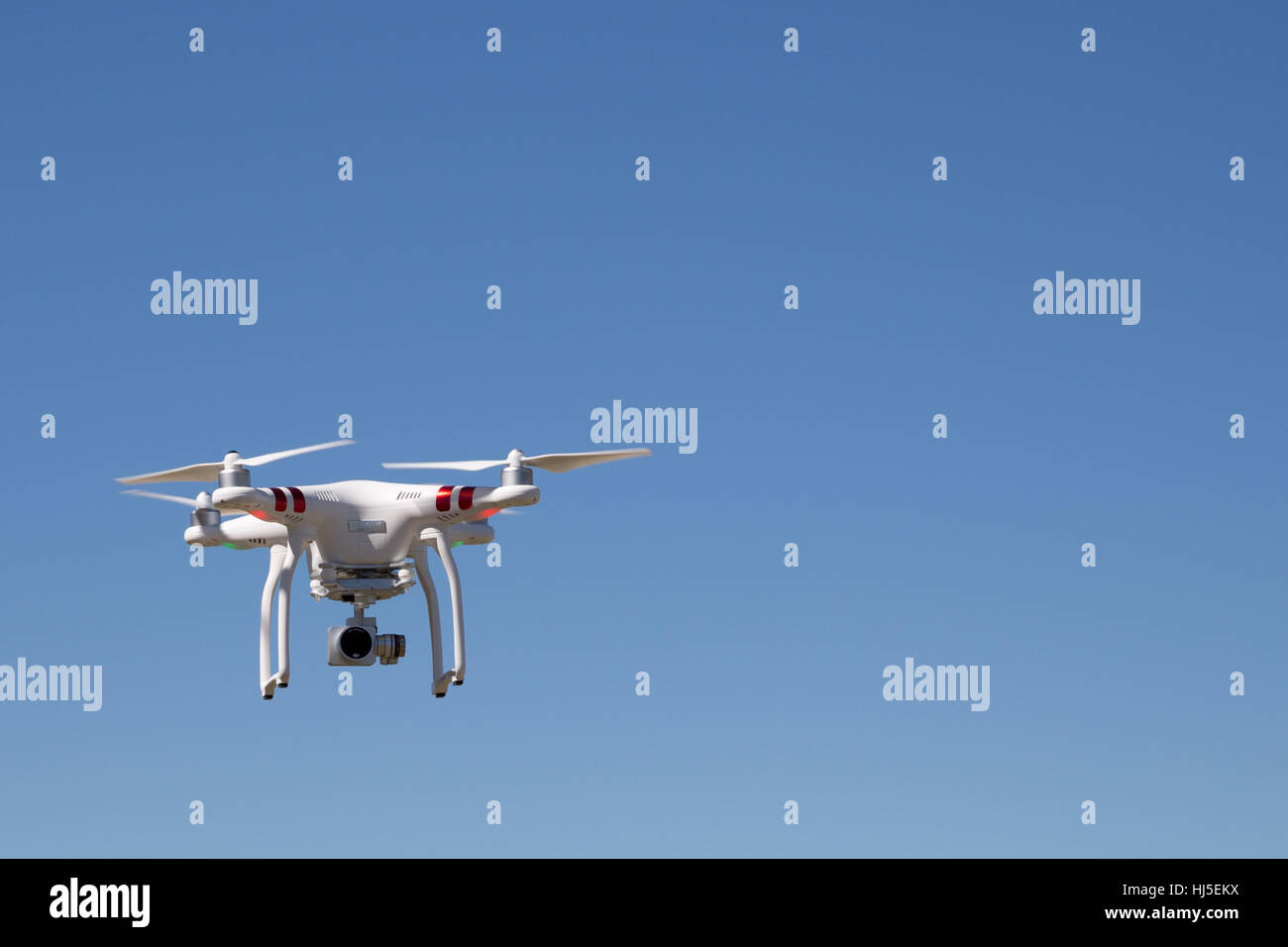 Unmanned Aerial Vehicle (UAV) or Drone against bright blue sky Stock Photo