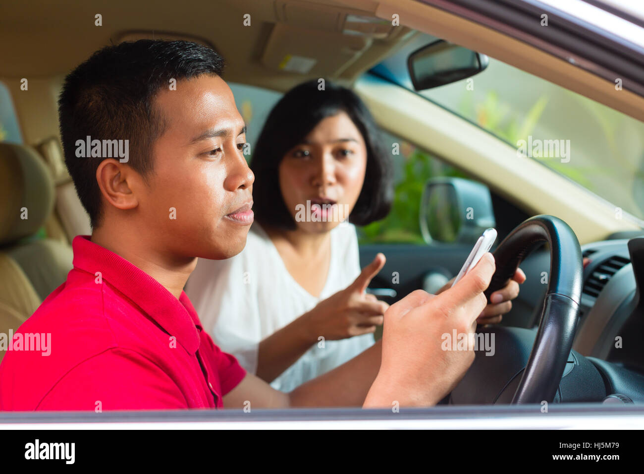 asian man writing sms while driving Stock Photo