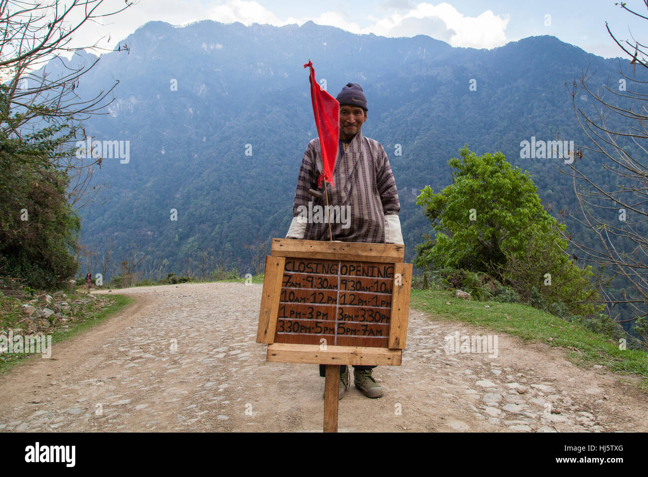 Roadwork blockade on the Gasa road. For regular road blasting and clearing landslides. Closure timings are on sign. Stock Photo