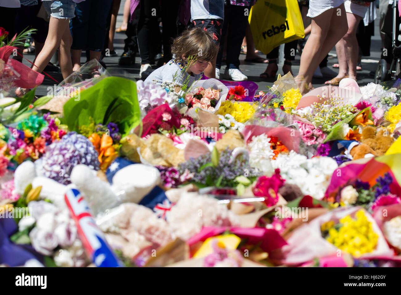 Melbourne, Australia. 22nd Jan, 2017. A child lays a floral tribute where people flocked to mourn for victims of the Bourke Street attack in Melbourne, Australia, Jan. 22, 2017. Credit: Bai Xue/Xinhua/Alamy Live News Stock Photo