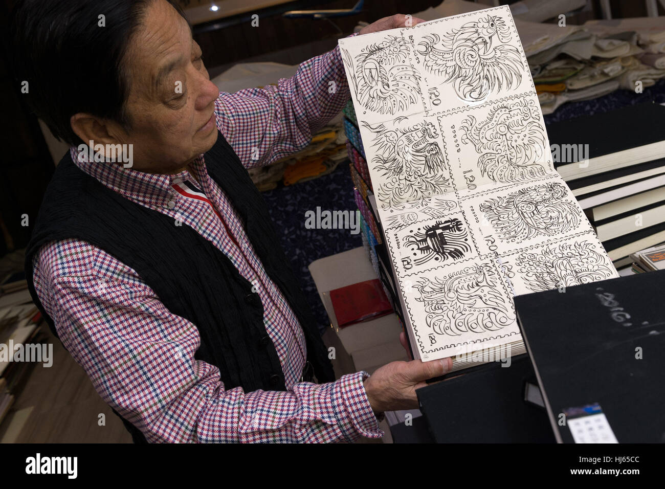 (170126) -- BEIJING, Jan. 26, 2017 (Xinhua) -- Chinese artist Han Meilin, 80, shows his sketches of roosters and hens for preparation of Chinese zodiac stamps for the upcoming Year of the Rooster at his studio in eastern district of Tongzhou in Beijing, capital of China, Jan. 24, 2017. Han, designer of the 2008 Beijing Olympic Games mascot "Fuwa," has just finished the design of Chinese zodiac stamps for the upcoming Year of the Rooster. The set of Chinese Lunar New Year rooster stamps, issued earlier this month, contain two items showing a rooster striding proudly and a hen looking after her Stock Photo