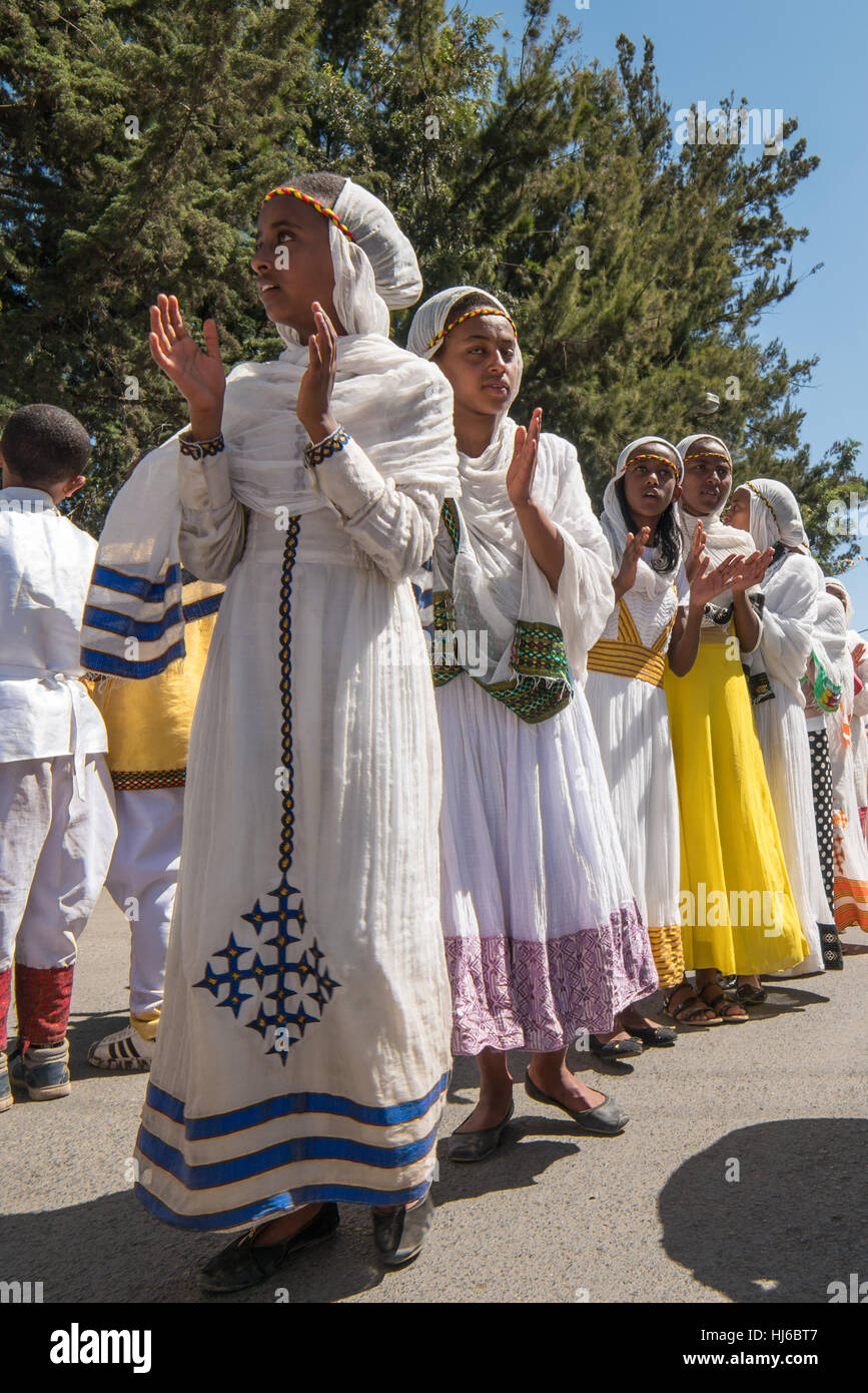 Addis Ababa - Jan 19: Young girls dressed in colorful traditional clothing sing and chant while accompanying the Tabot, a model of the arc of covenant Stock Photo
