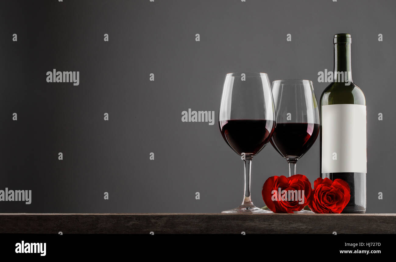 Two glasses and bottle of red wine, heart shaped roses, Valentine day ...