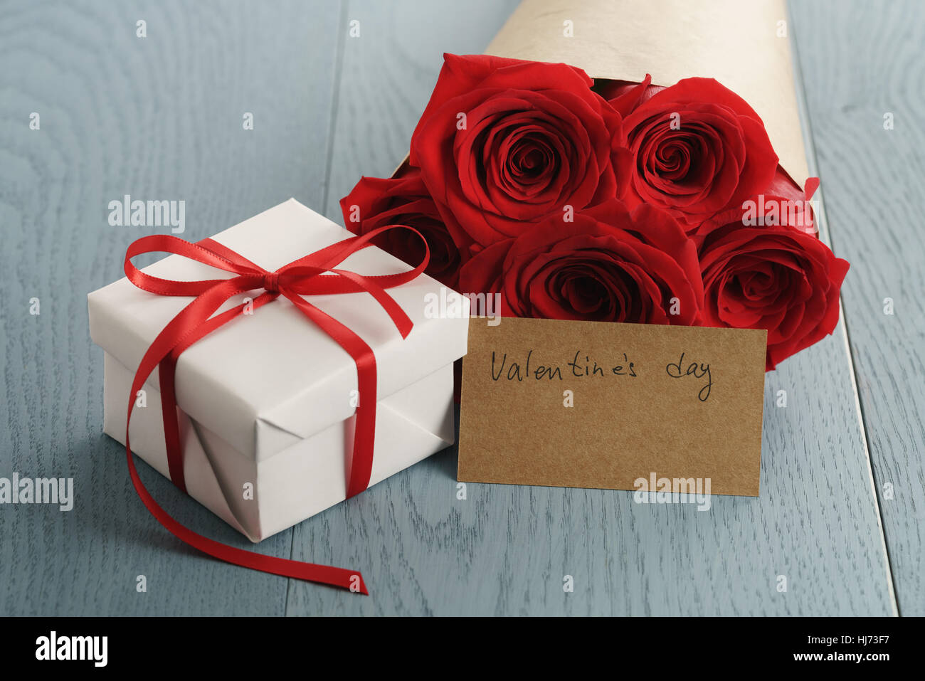 bouquet of red roses on blue wood table with gift and valentines day ...