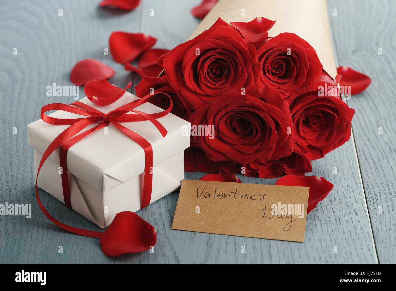 bouquet of red roses on blue wood table with gift and valentines day ...