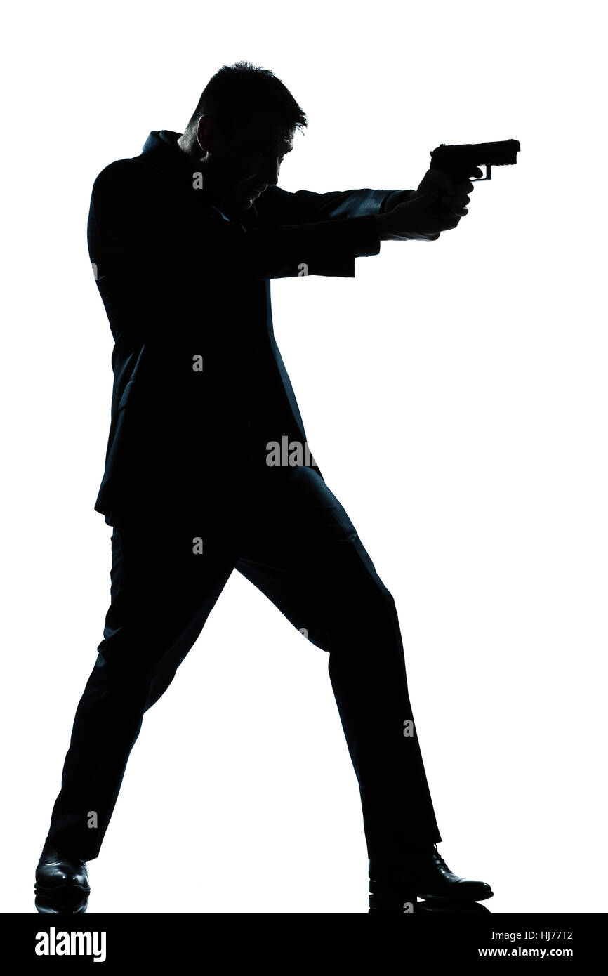 one caucasian spy criminal policeman detective man aiming shooting gun  full length silhouette in studio isolated white background Stock Photo
