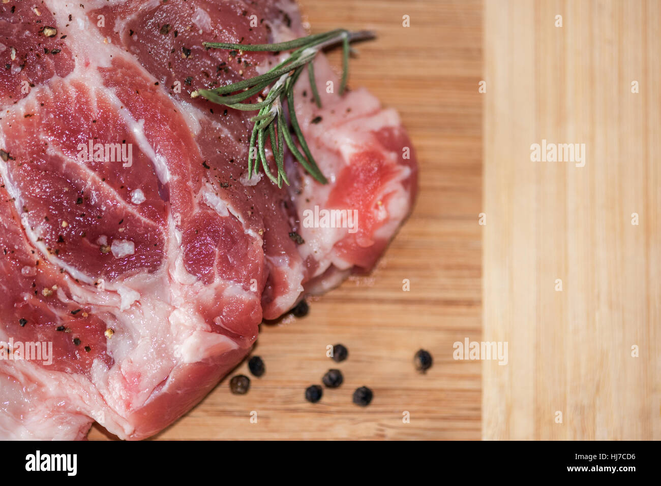 Raw pork steak on wooden board. Stock Photo