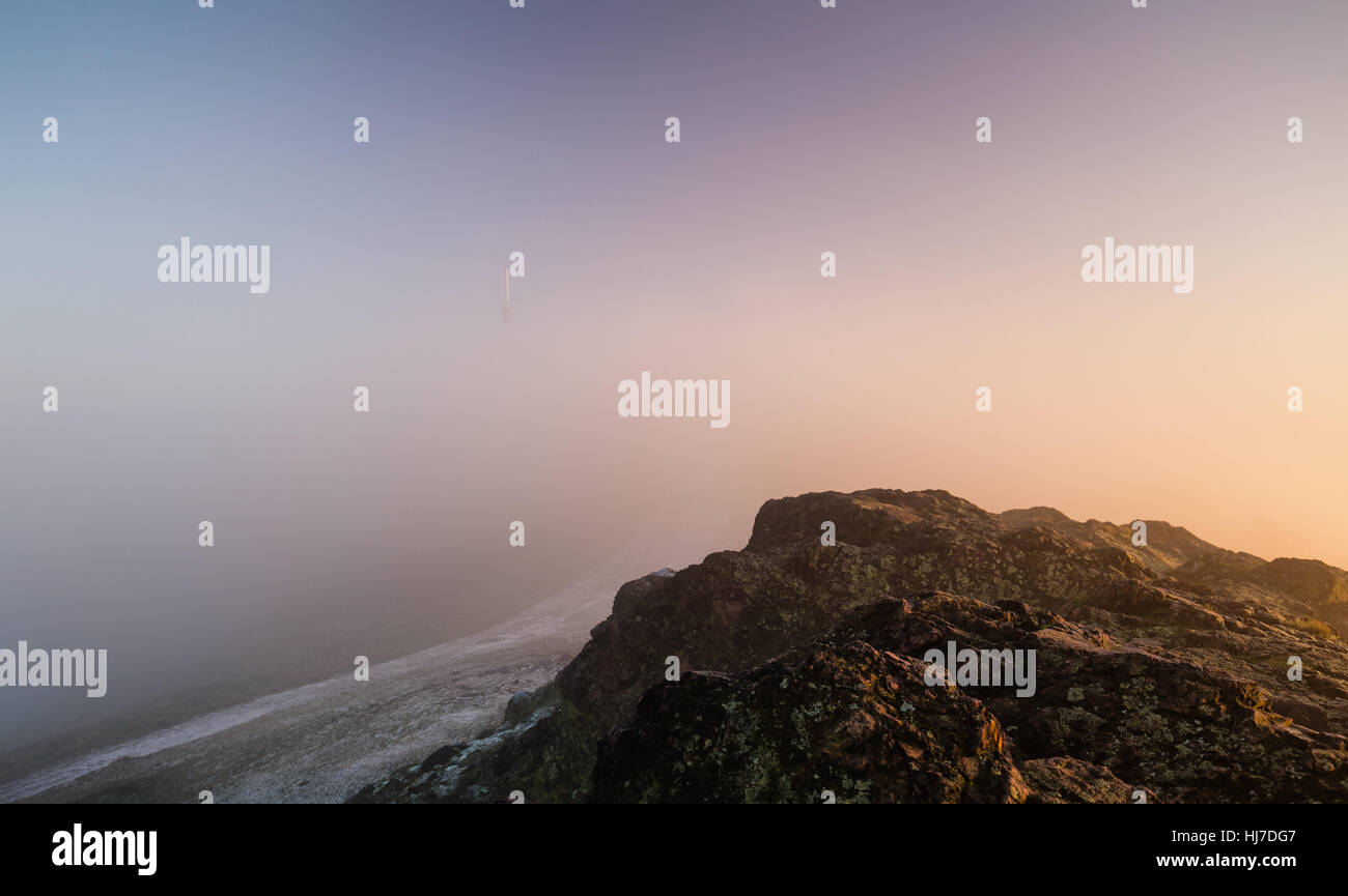 Summit of Rocky Hill in Fog at Sunrise Stock Photo