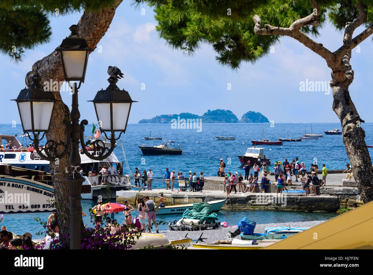 Tourists gather at a boat marina for boat tours along the Amalfi Coastline in Italy. Stock Photo