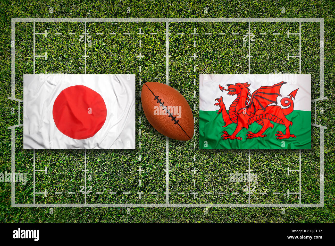 Japan vs. Wales flags on green rugby field Stock Photo