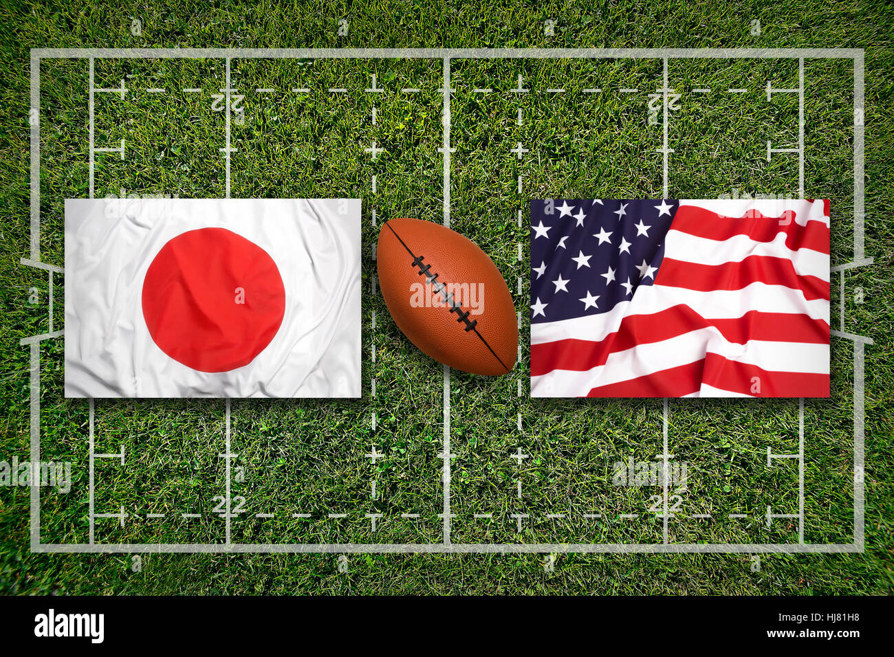 Japan vs. USA flags on green rugby field Stock Photo