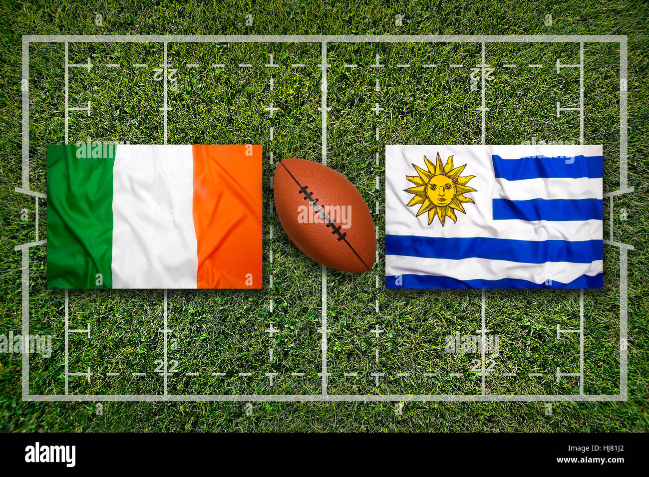 Ireland vs. Uruguay flags on green rugby field Stock Photo