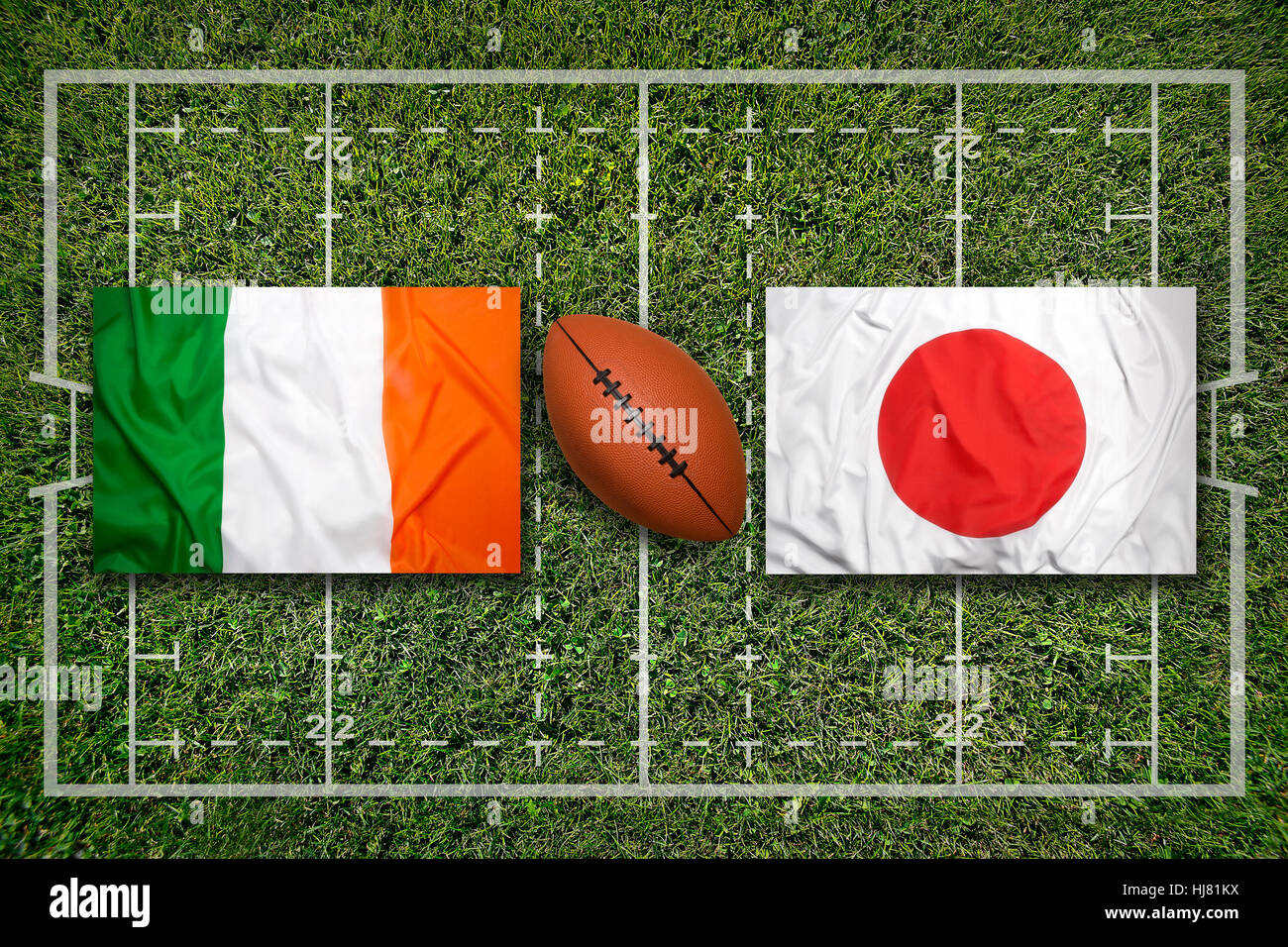 Ireland vs. Japan flags on green rugby field Stock Photo