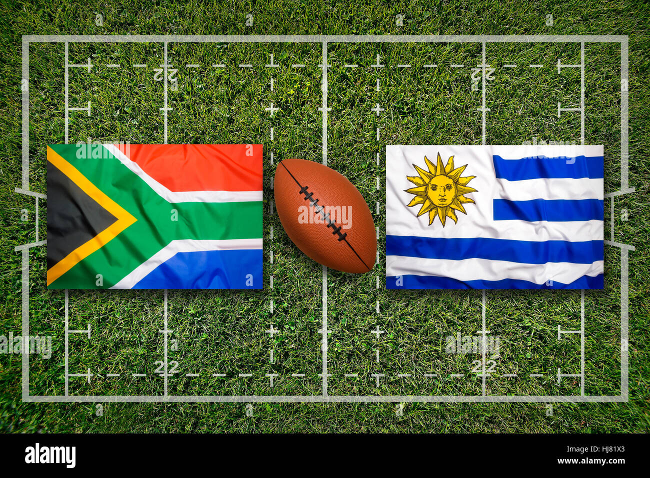 South Africa vs. Uruguay flags on green rugby field Stock Photo