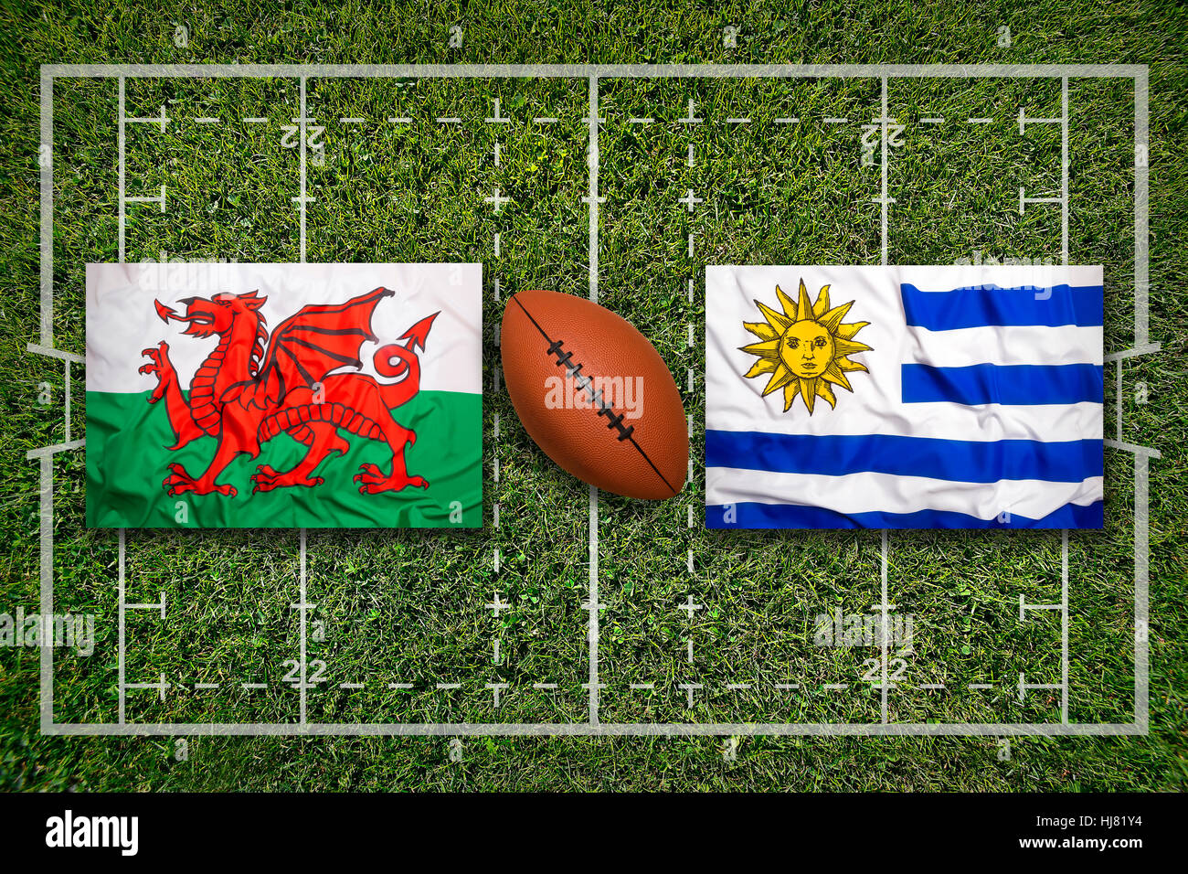 Wales vs. Uruguay flags on green rugby field Stock Photo
