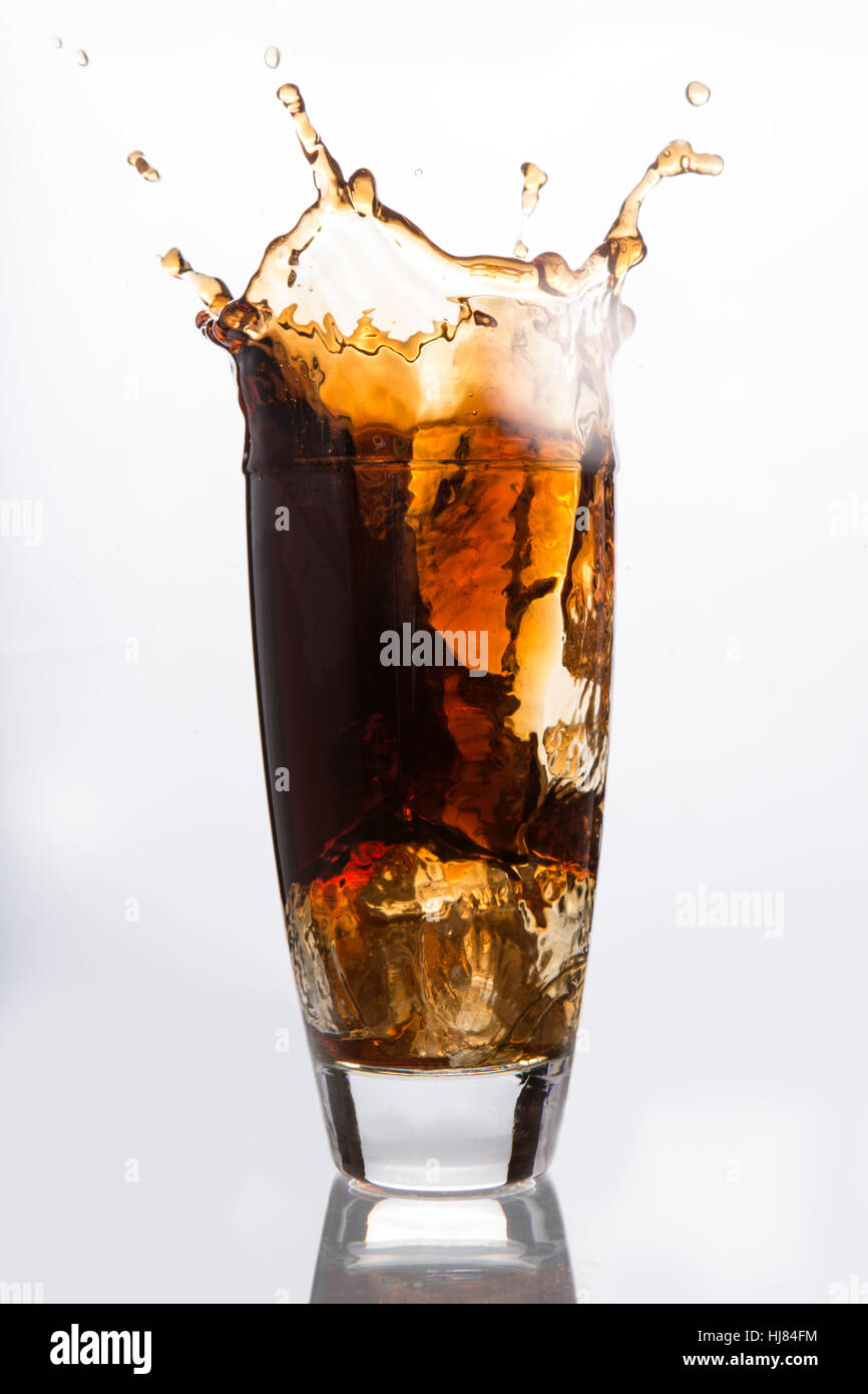 Ice cube falling into a glass of soda on white background Stock Photo ...