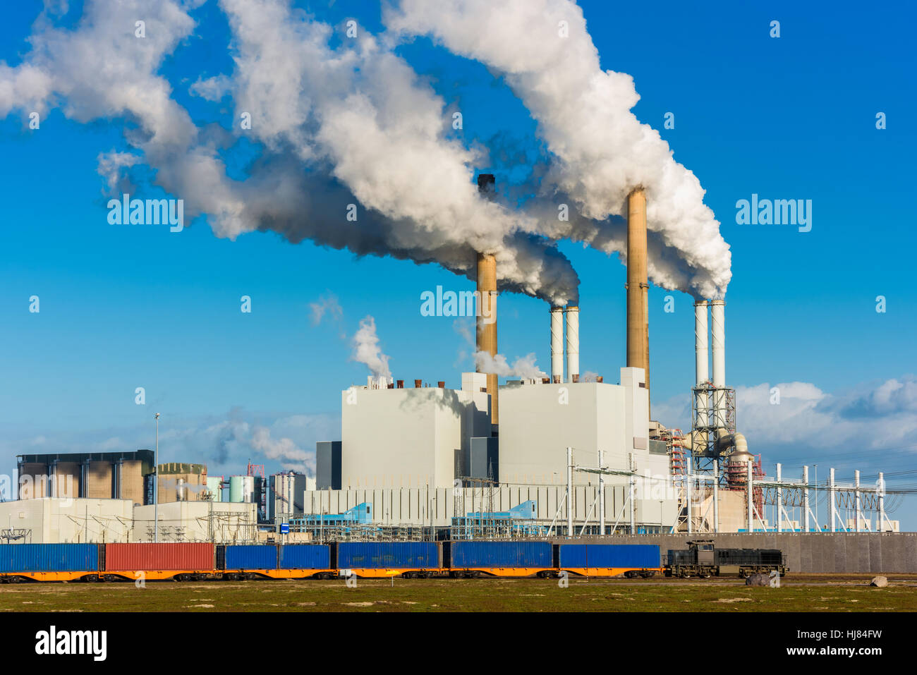 Freight Train passing Power Plant in Harbour of Rotterdam Stock Photo