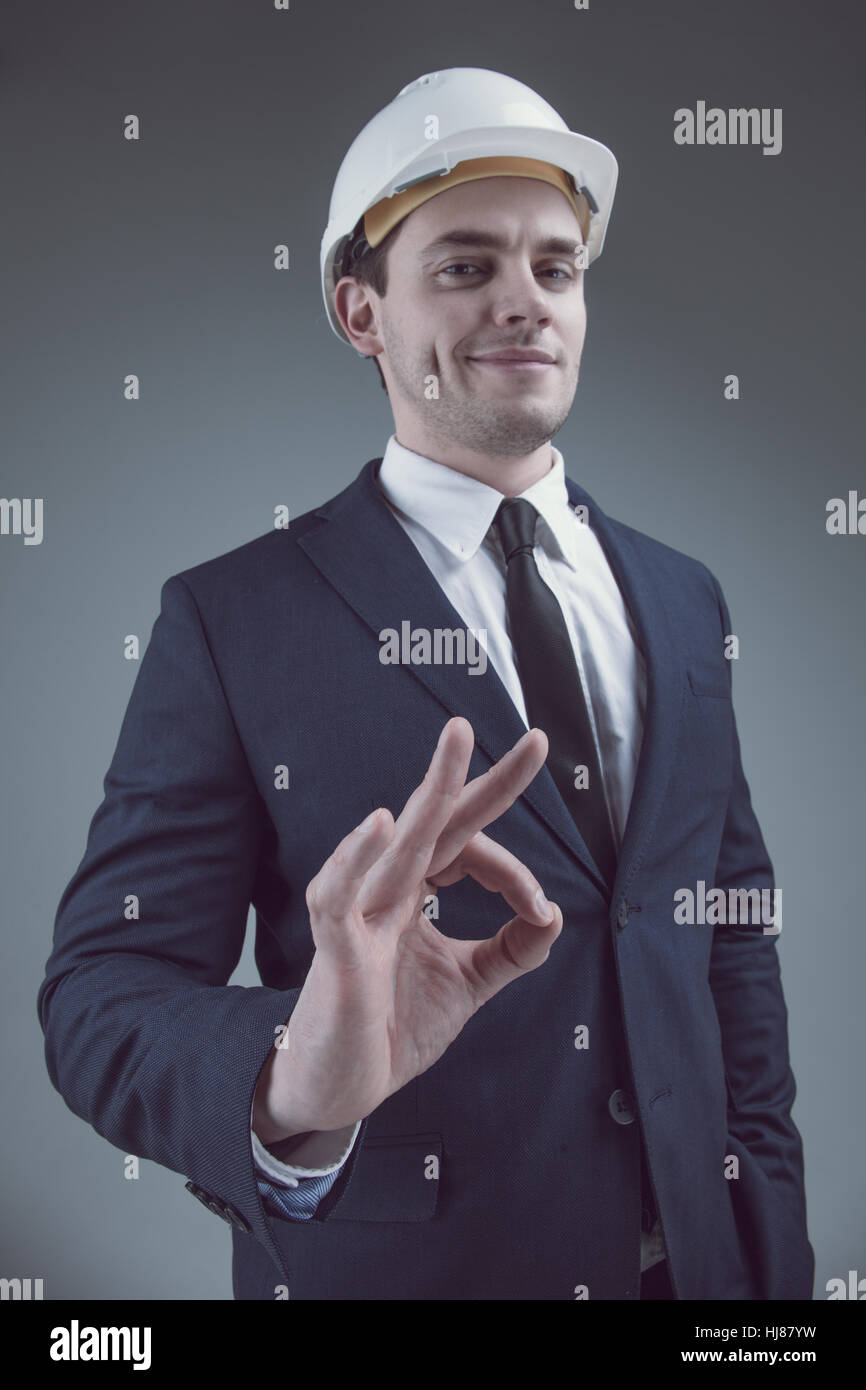 Portrait of a businessman in white helmet on gray background Stock Photo