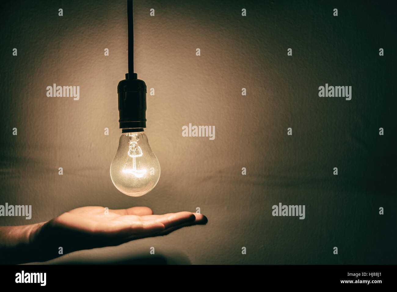 light bulb and hand with dark background Stock Photo