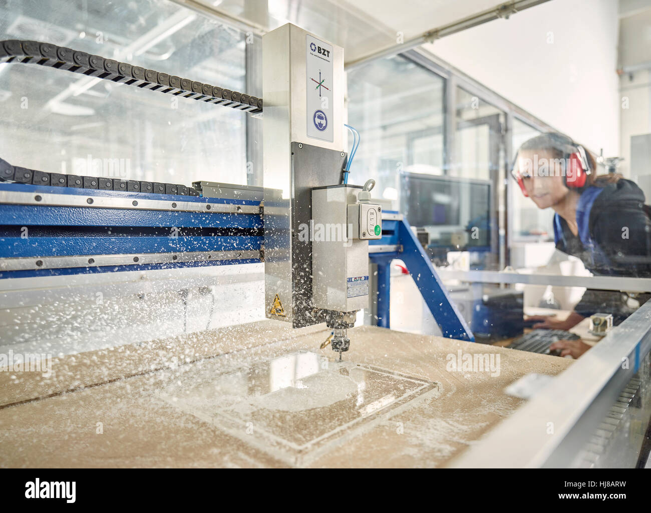 Woman with ear protection operates CNC milling machine, CNC machine, Austria Stock Photo