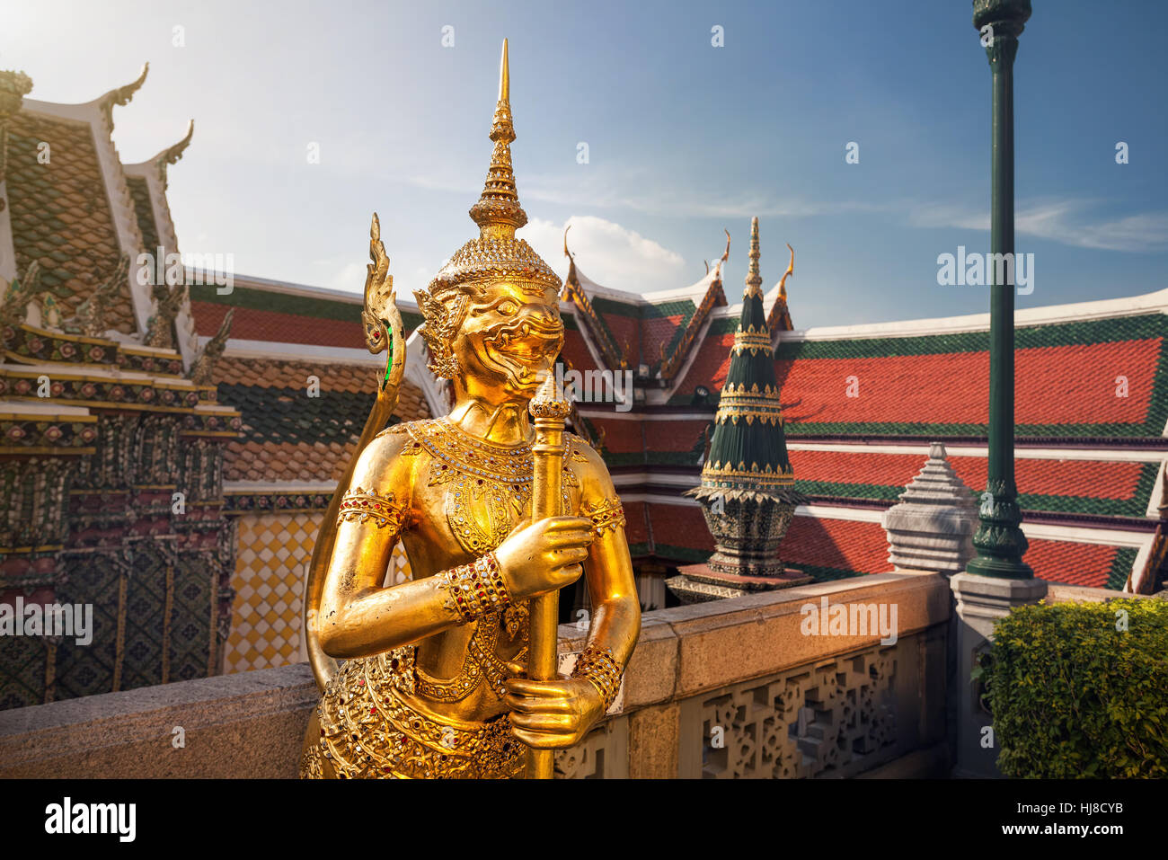 Golden Guardian Statue in the Temple of the Emerald Buddha Wat Phra Kaew in Bangkok at sunset Stock Photo