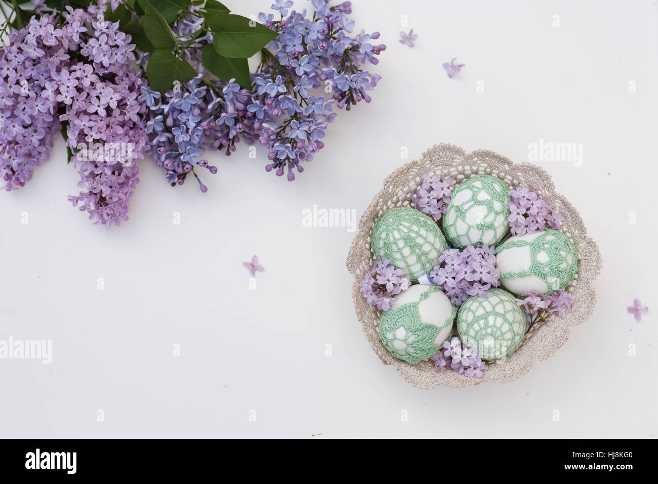 Handmade Easter eggs in a basket and Lilac flowers Stock Photo