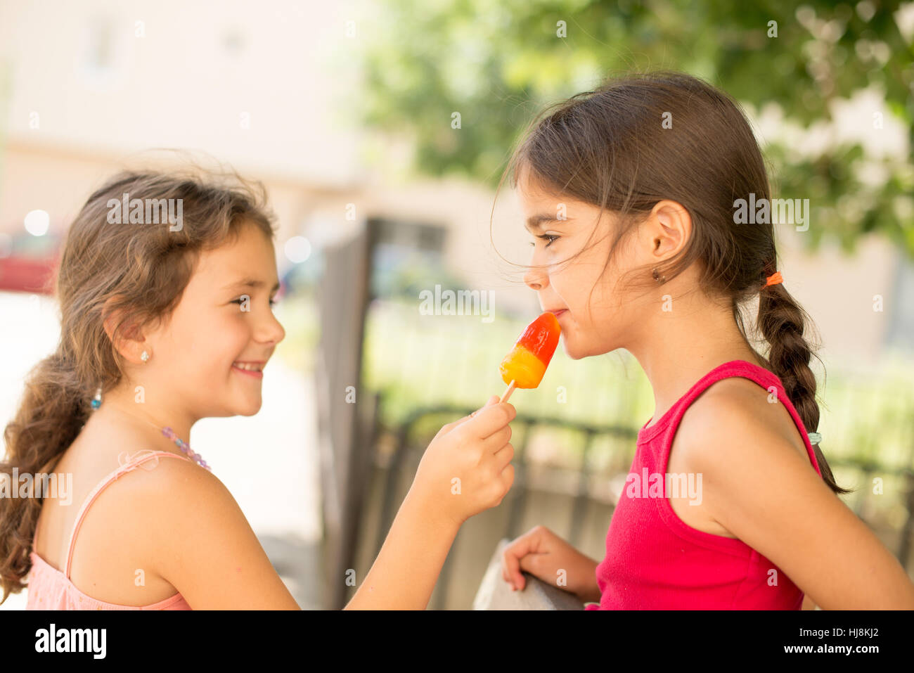 Two girls sharing an ice-lolly Stock Photo