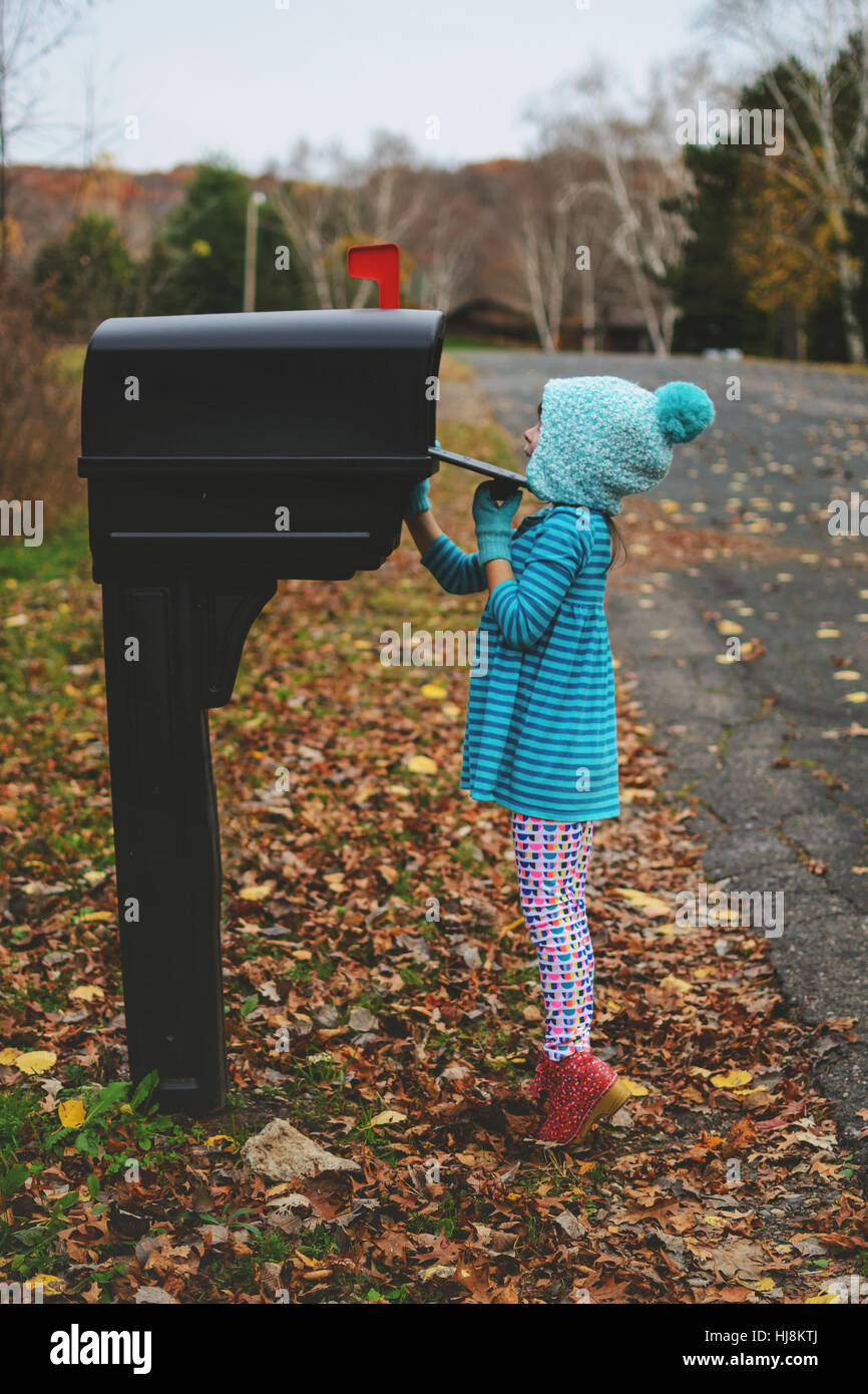 Girl checking the mail box in the street Stock Photo Alamy