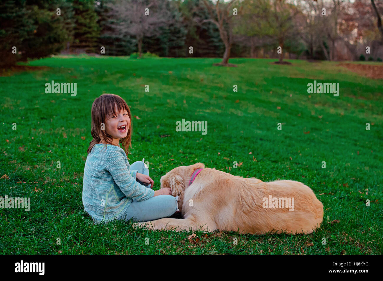 Girl playing with her golden retriever dog in garden Stock Photo - Alamy